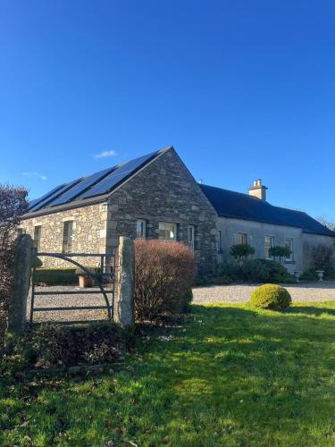 a barn with solar panels on the side of it at Drummin Cottage in Tinahely