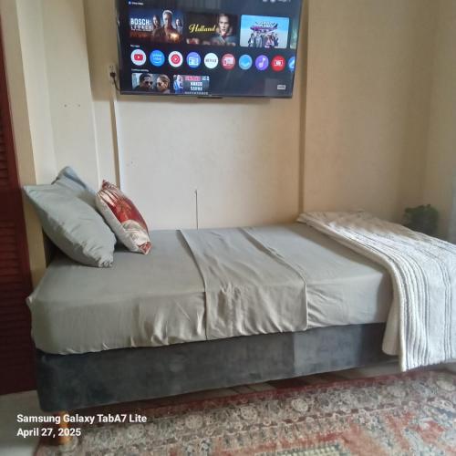 een slaapkamer met een bed en een tv aan de muur bij Jazz Apartment 2 in Christ Church