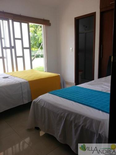 two beds in a room with a window at Finca Campestre Villa Andrea in Restrepo