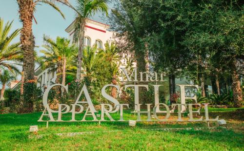 a sign in the grass in front of a building at Mnar Castle in Tangier