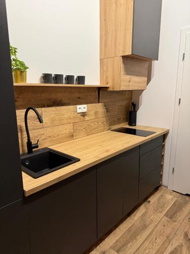 a kitchen with a sink and a wooden counter top at ZaciszeHouse in Noworąblów
