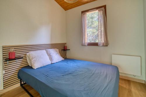 une chambre avec un lit bleu avec une fenêtre dans l'établissement Le Cocon de Suzac - 6 pers - Mer, à Saint-Georges-de-Didonne
