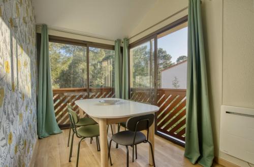 une salle à manger avec une table et des chaises sur un balcon dans l'établissement Le Cocon de Suzac - 6 pers - Mer, à Saint-Georges-de-Didonne