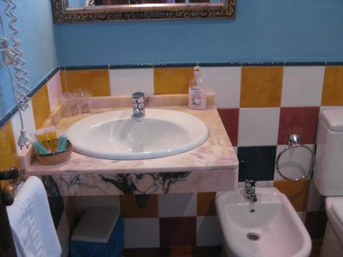 a bathroom with a sink and a toilet at Hostal El Cascapeñas de la Alpujarra in Capileira