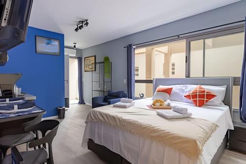 a bedroom with a large bed with a blue wall at Nik Perdizes in Sao Paulo