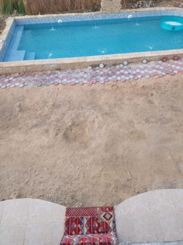 a swimming pool with a tile floor and a mosaic sidx sidx sidxktopktopktop at Dr house in Siwa