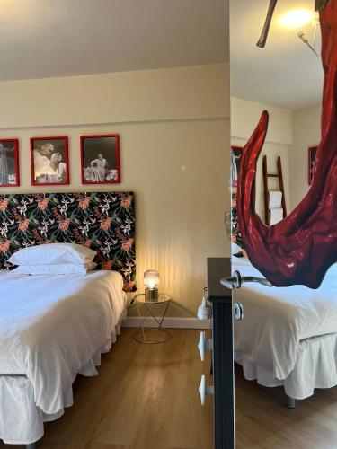 Un dormitorio con dos camas y un cabecero de sirena rojo. en La Casetta di Borgo -Appartamento Peperone, en Lajatico