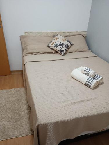 two twin beds in a room with a pillow at Ape Buritis, á 5 minutos do Aeroporto in Várzea Grande