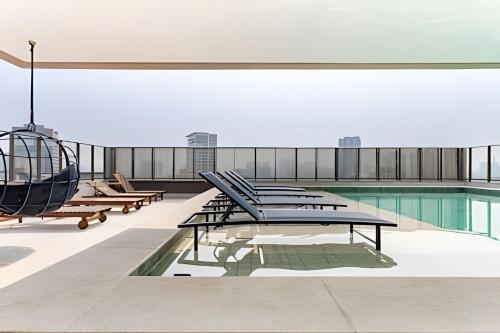 a building with a swimming pool and a helicopter at Nik Perdizes in Sao Paulo