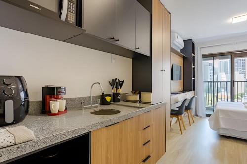 a kitchen with a sink and a counter top at Nik Perdizes in Sao Paulo