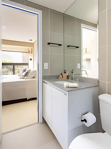 a bathroom with a sink and a toilet and a bed at Nik Perdizes in Sao Paulo