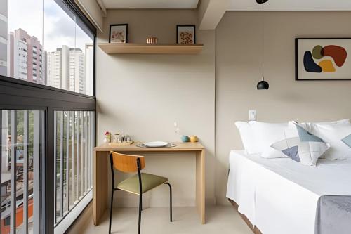 a bedroom with a desk and a bed and a window at Nik Perdizes in Sao Paulo