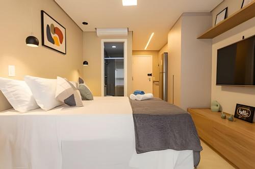 a bedroom with a large bed and a flat screen tv at Nik Perdizes in Sao Paulo