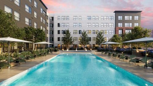 a rendering of a hotel pool with chairs and umbrellas at Luxury Apartments by Hyatus at Boston Everett in Everett