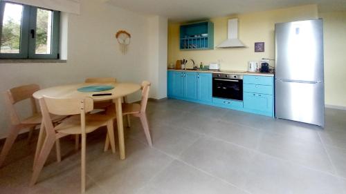 a kitchen with blue cabinets and a table and a refrigerator at Marmaras Mani Houses in Riglia