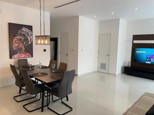 a dining room with a table and chairs and a tv at Bubali Modern Suites in Palm-Eagle Beach