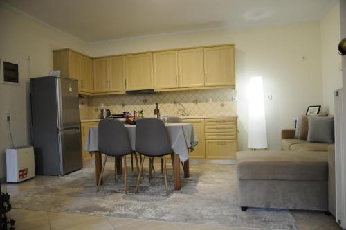 a kitchen with a table with chairs and a refrigerator at Franceska's guest house in Artemida
