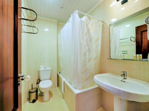 a bathroom with a white toilet and a sink at Hotel Vale Verde in Furnas