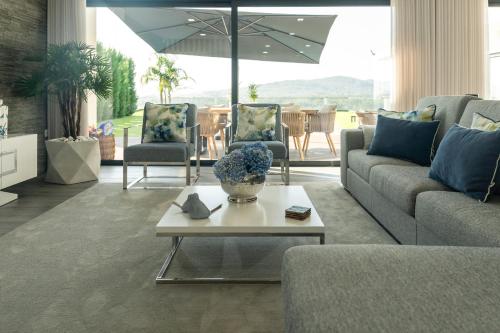 a living room with a couch and chairs and an umbrella at Vietnam house in Areias de Vilar