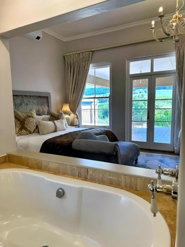 een grote slaapkamer met een bad en een bed bij Franschoek Lermitage Villa Two Bedroom Lake View in Franschhoek