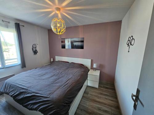 une chambre avec un lit et un lustre dans l'établissement Charmante maison avec piscine et jaccuzi en Provence, à Morières-lès-Avignon