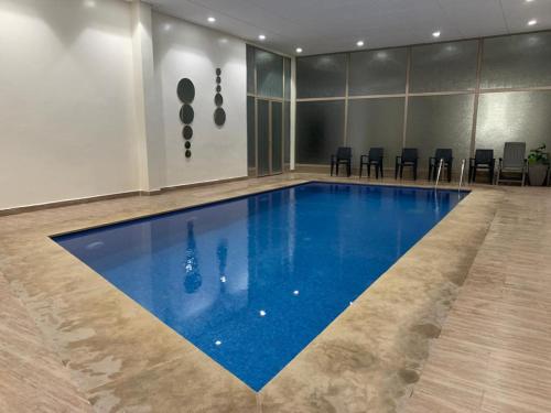 a large swimming pool in a room with chairs at luxury Aprt2 bedrooms Pool hivernage heart of city in Marrakech