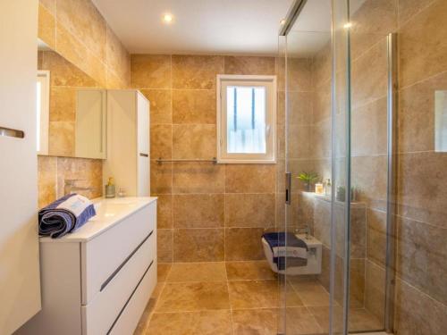 une salle de bain avec une douche en verre et un lavabo dans l'établissement Villa avec piscine 2 chambres 4 couchages, à Cavalaire-sur-Mer