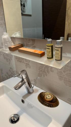 a bathroom sink with a mirror and a soap dispenser at Tropicana Room in Caserta