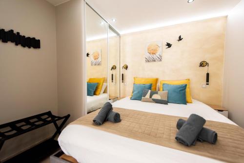 - une chambre avec un grand lit blanc et des oreillers colorés dans l'établissement Sunny Palazzio T3 Old Port, Beaches, Congress, à Cannes