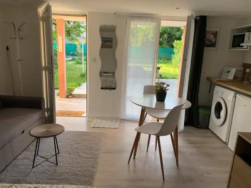 a kitchen and living room with a table and chairs at 'StudioCDG fr' Jardin, Studio proche near CDG Roissy airport, Parc Expositions, Stade de France, Arena, Disney, Asterix in Villepinte