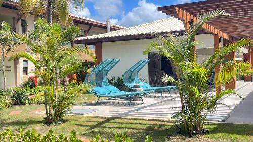 a patio with blue chairs on a house at Bioflora Residence Itacimirim in Camacari