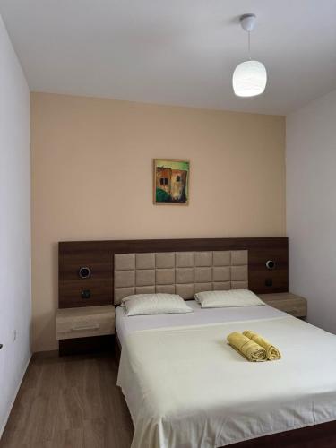 a bedroom with a large white bed with a headboard at Apartmants S&H in Ulcinj