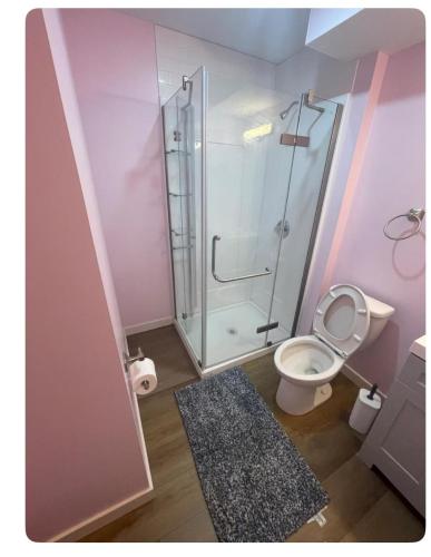 a bathroom with a toilet and a glass shower at Bedroom in Upland D in Edmonton