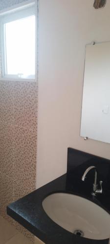 a bathroom with a sink and a window at Casa suíte privativa in Campinas