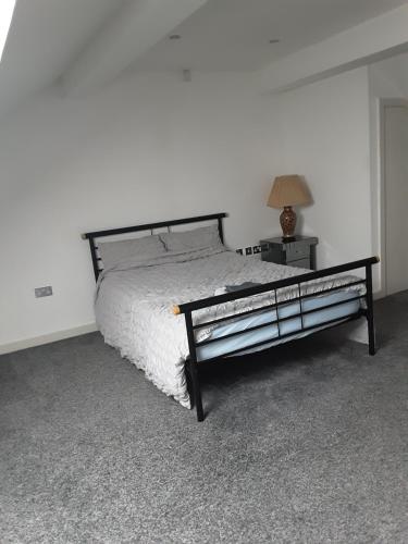 a bedroom with a bed and a lamp on a table at Three bedroom apartment Darlington Victoria Road in Darlington