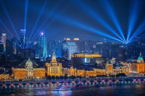 a night view of a city with a river and buildings at Pudong Shangri-La Shanghai - With a sweeping view of the Pearl Tower and the historic Bund skyline in Shanghai