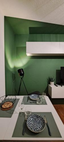 a table with plates and utensils on a green wall at Charmant studio à Castres in Castres