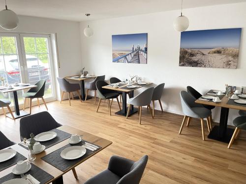 a restaurant with tables and chairs and a bridge at Pension Frisia in Norddeich