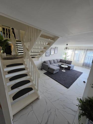 a living room with a staircase and a couch at Lugn & Ro på Vändstigen in Nybro