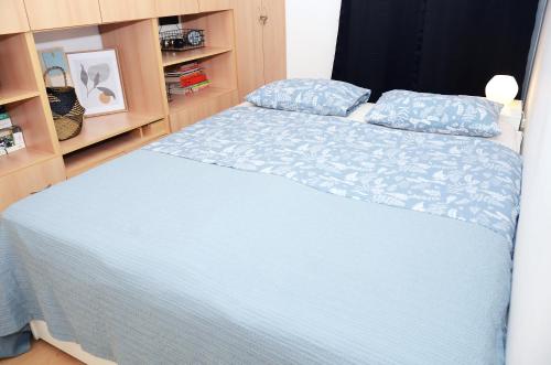 a bedroom with a bed with a blue comforter at Zlatna Boska in Kotor