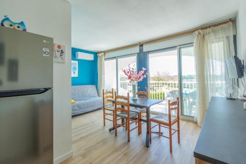 une cuisine et une salle à manger avec une table et des chaises dans l'établissement Mer et Dune, à La Grande Motte