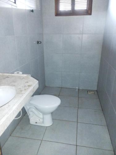 a white bathroom with a toilet and a sink at casa do conde in Luis Correia