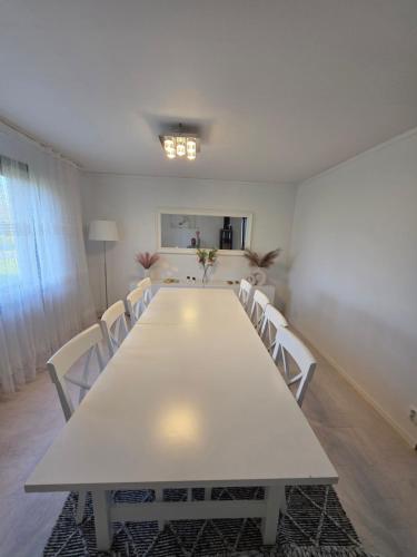 a large white table and chairs in a room at Lugn & Ro på Vändstigen in Nybro