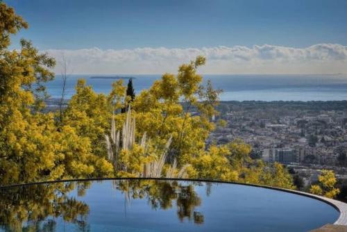 a large pool of water on top of a hill at Luxury Modern Provencal Villa Infinity Pool Epic Seaview near Cannes Festival-Ready in Mandelieu-la-Napoule