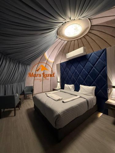 a bedroom with a bed with a blue wall at Mars Land Luxury Camp in Wadi Rum