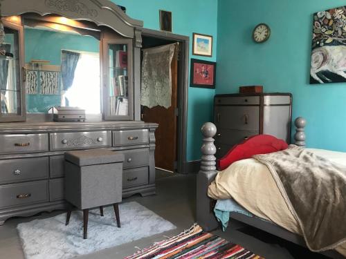 a bedroom with a bed with a dresser and a mirror at Charming Bohemian Rental in Philadelphia