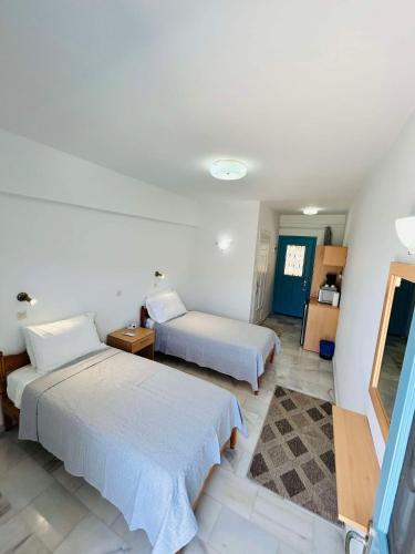 a hotel room with two beds and a mirror at Studio Saroukos in Kalymnos
