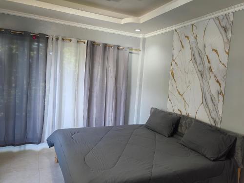 a bedroom with a bed and a large window at Eazy Stay Room Rental in Panglao