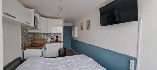 Cette petite chambre comprend un lit et une cuisine. dans l'établissement superbe studio avec piscine, ascenseur et accès direct sur le port, au Cap d'Agde