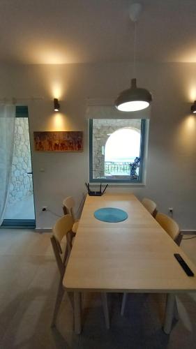 a dining room with a wooden table and chairs at Marmaras Mani Houses in Riglia